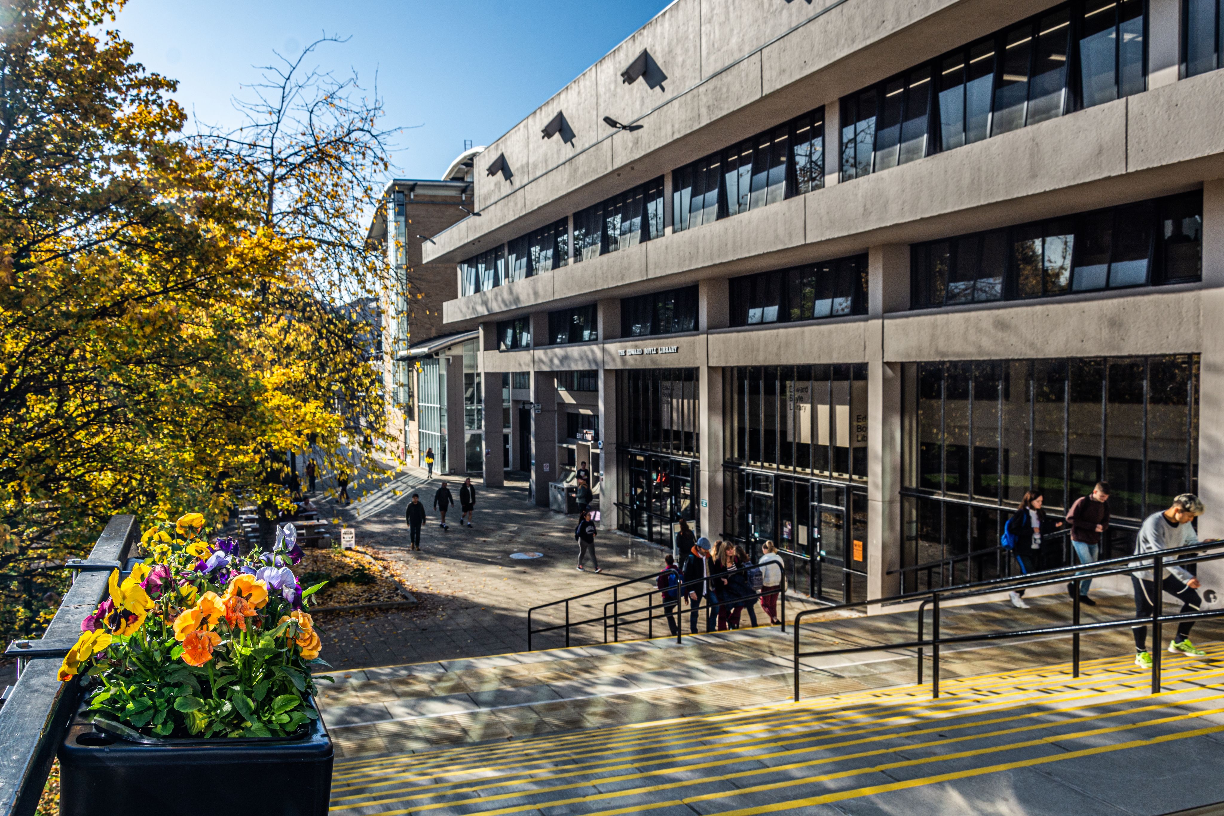 Students walk down the steps towards the main entrance of the Edward Boyle Library
