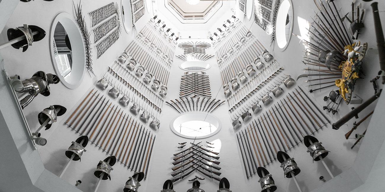 Hundreds of pieces of weaponry as decoration on high walls at the Royal Armouries.