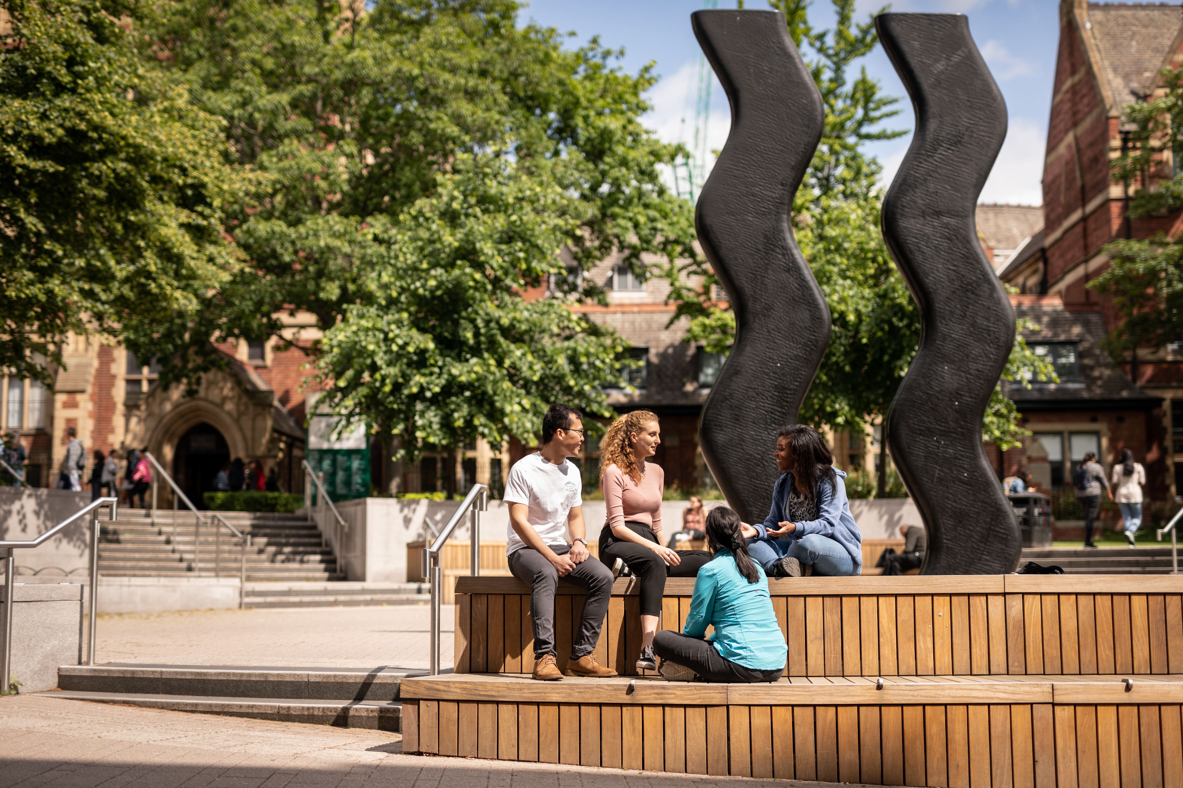 Students sat by the Sign of Art Sculpture in Beech Grove Plaza 