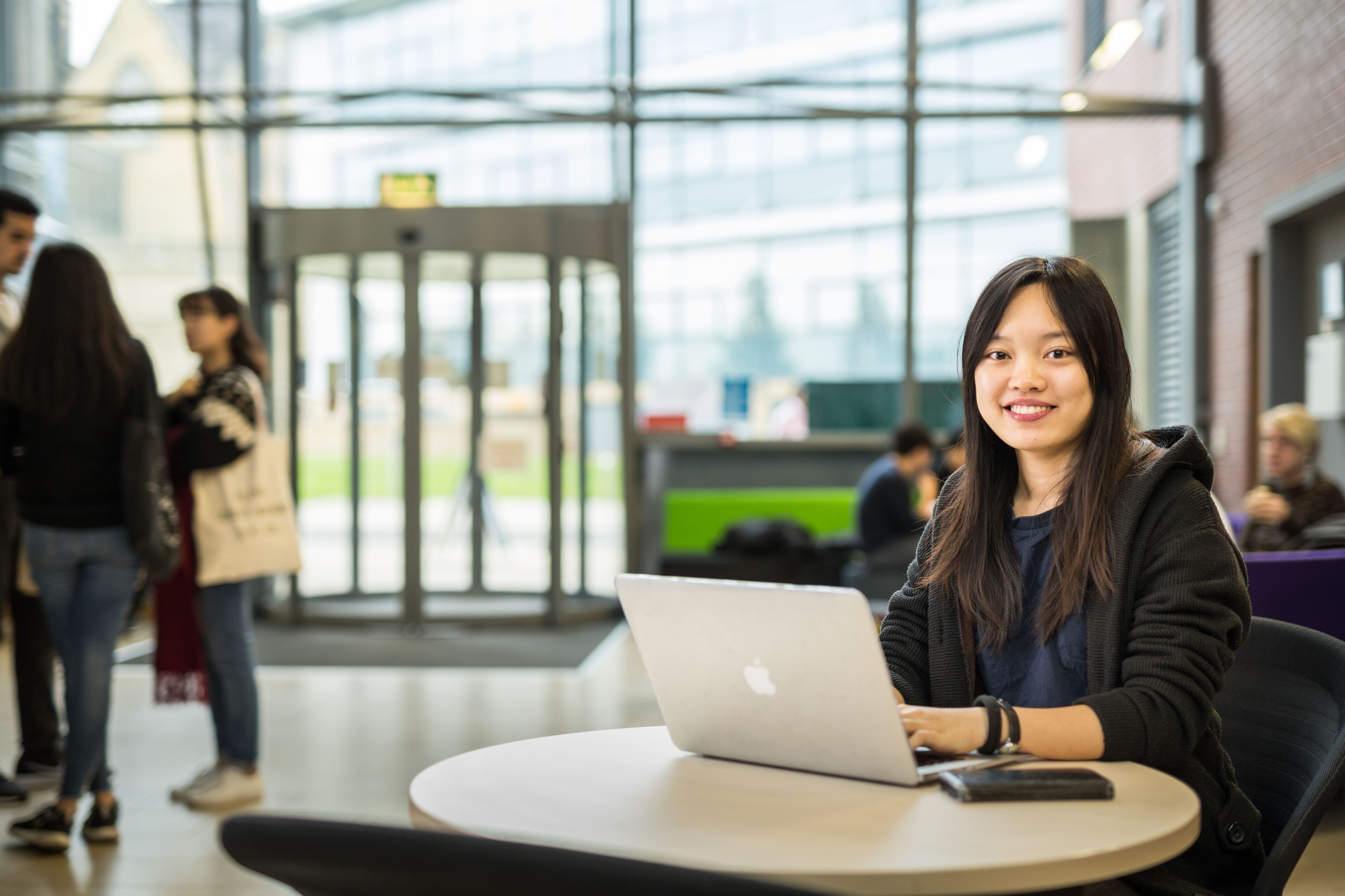 male students sat outside the school of english on wall 