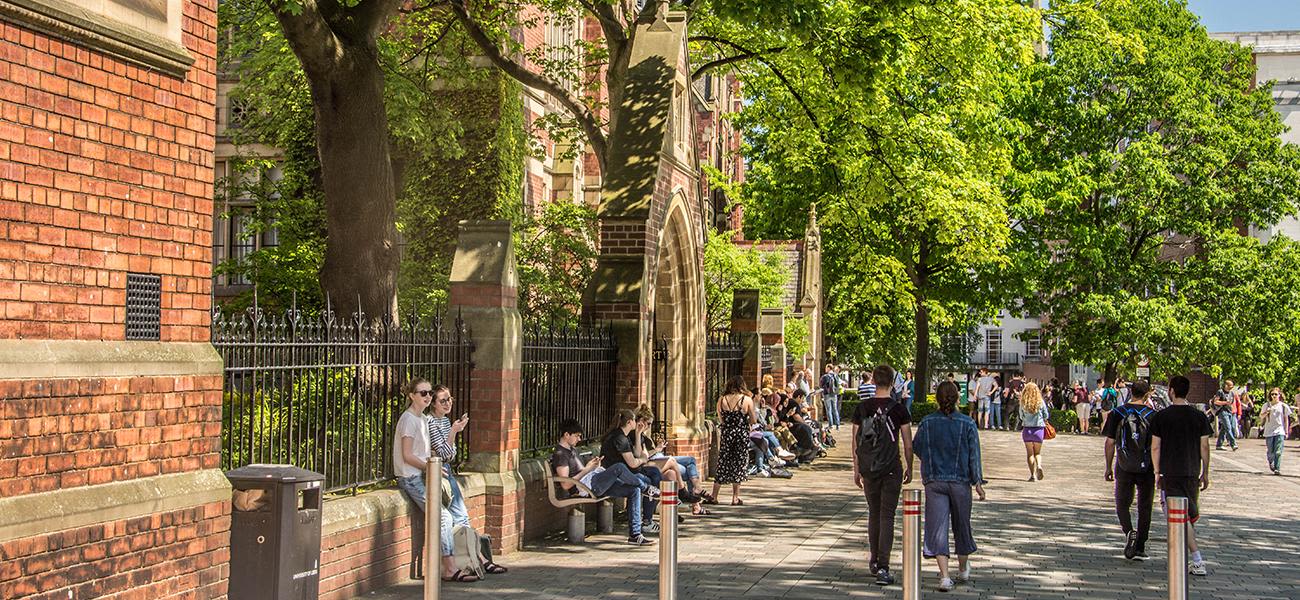 Campus in summer in front of Great Hall. Groups of people sitting and walking.