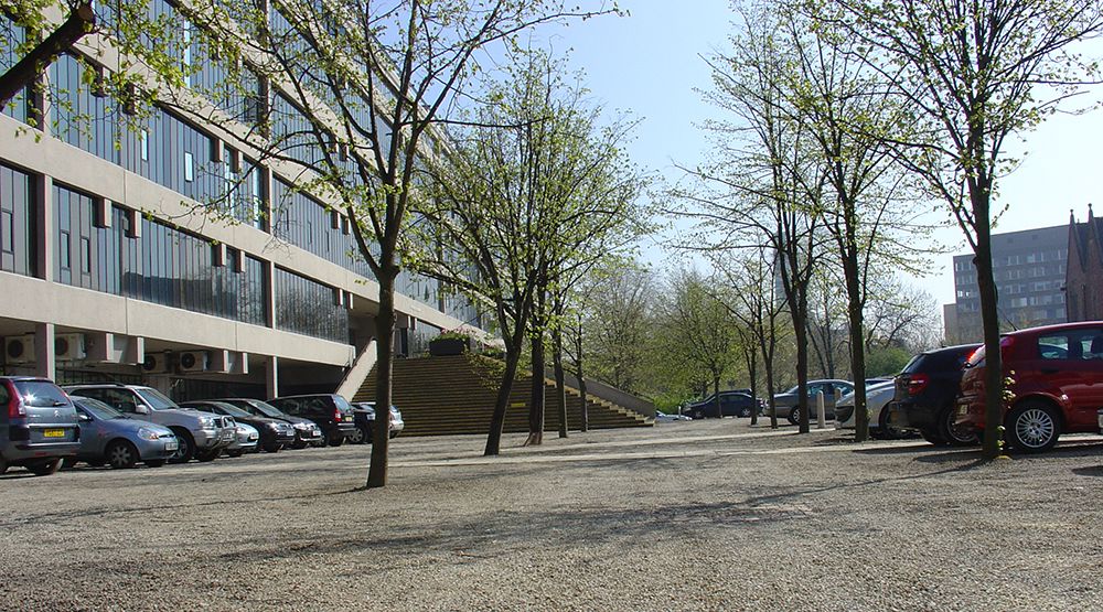 Cars parked on gravel in front of the EC Stoner Building