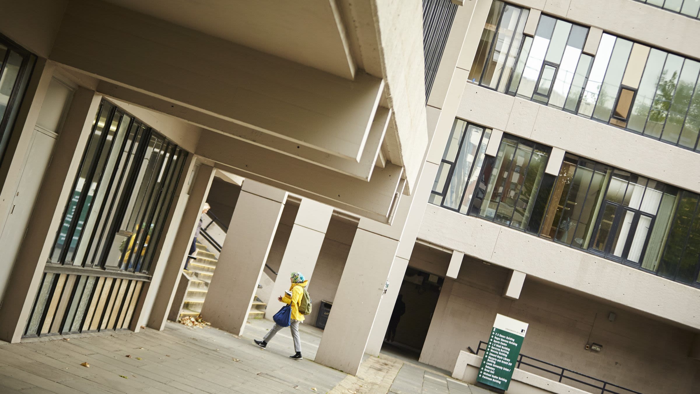 Person walking toward stairs surround by Brutalist architecture