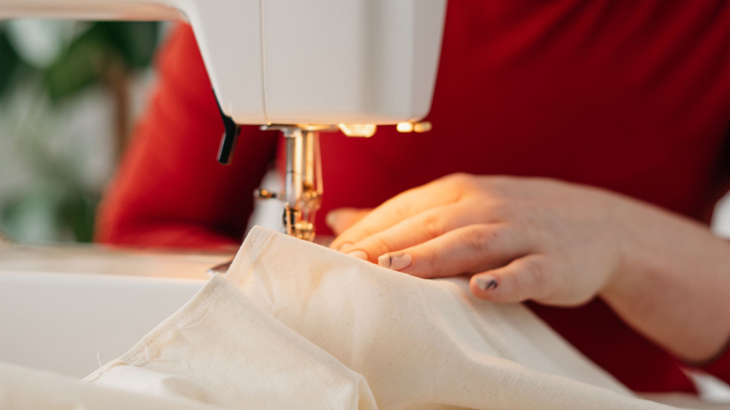 Close up of the hand of a person using a sewing machine