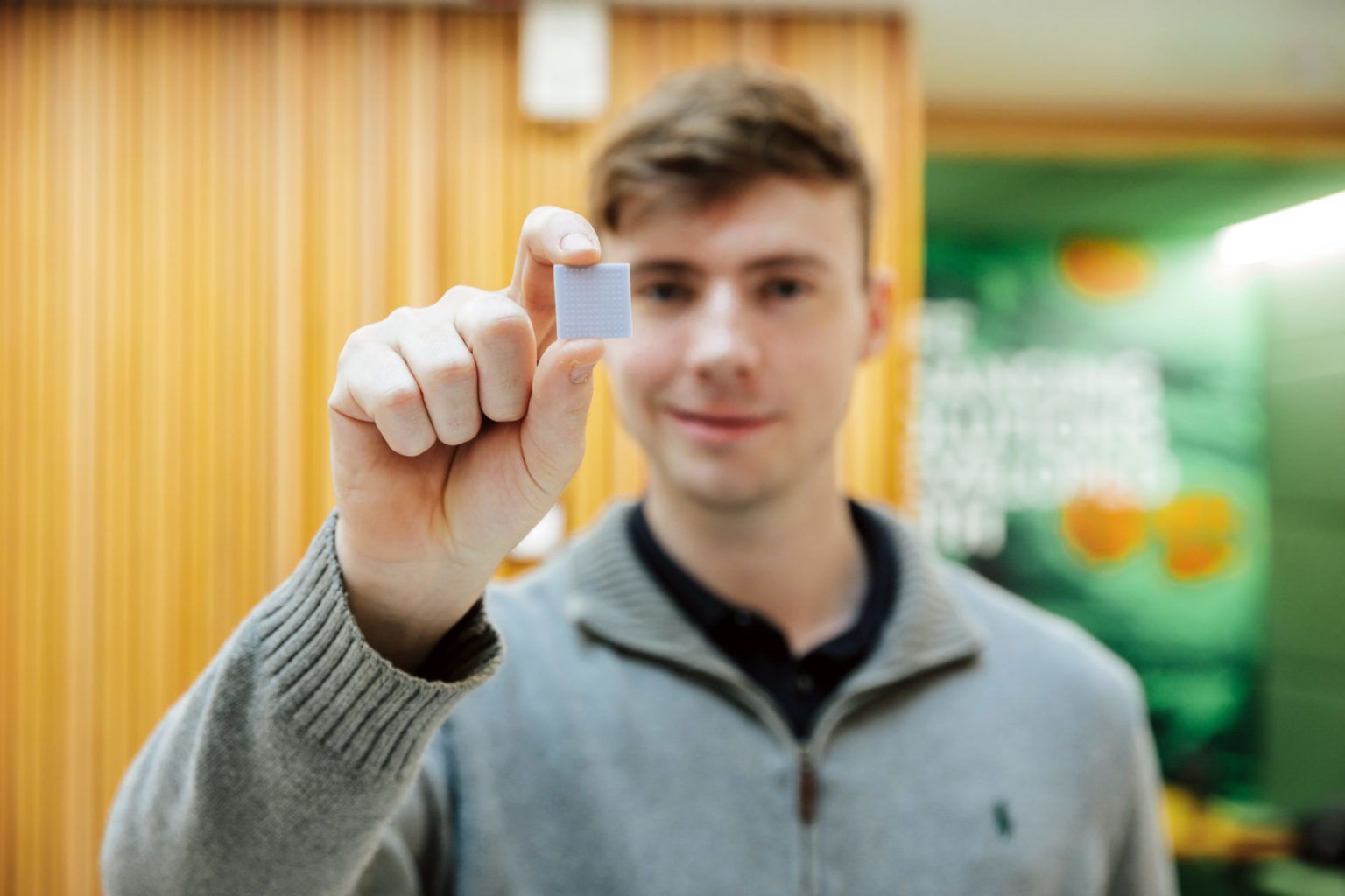 Henry Dunne, co-founder of Microneedle solutions holds up a small square microscopic needle patch.