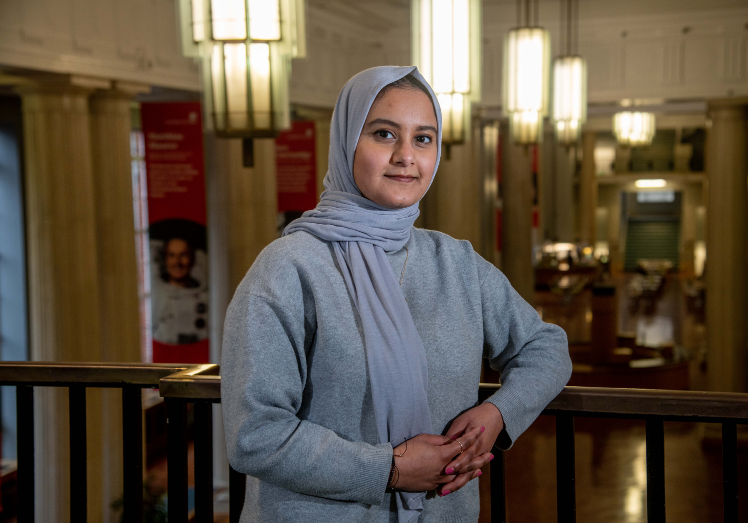 Bushran Hasan leans upon the balcony in the Brotherton Library