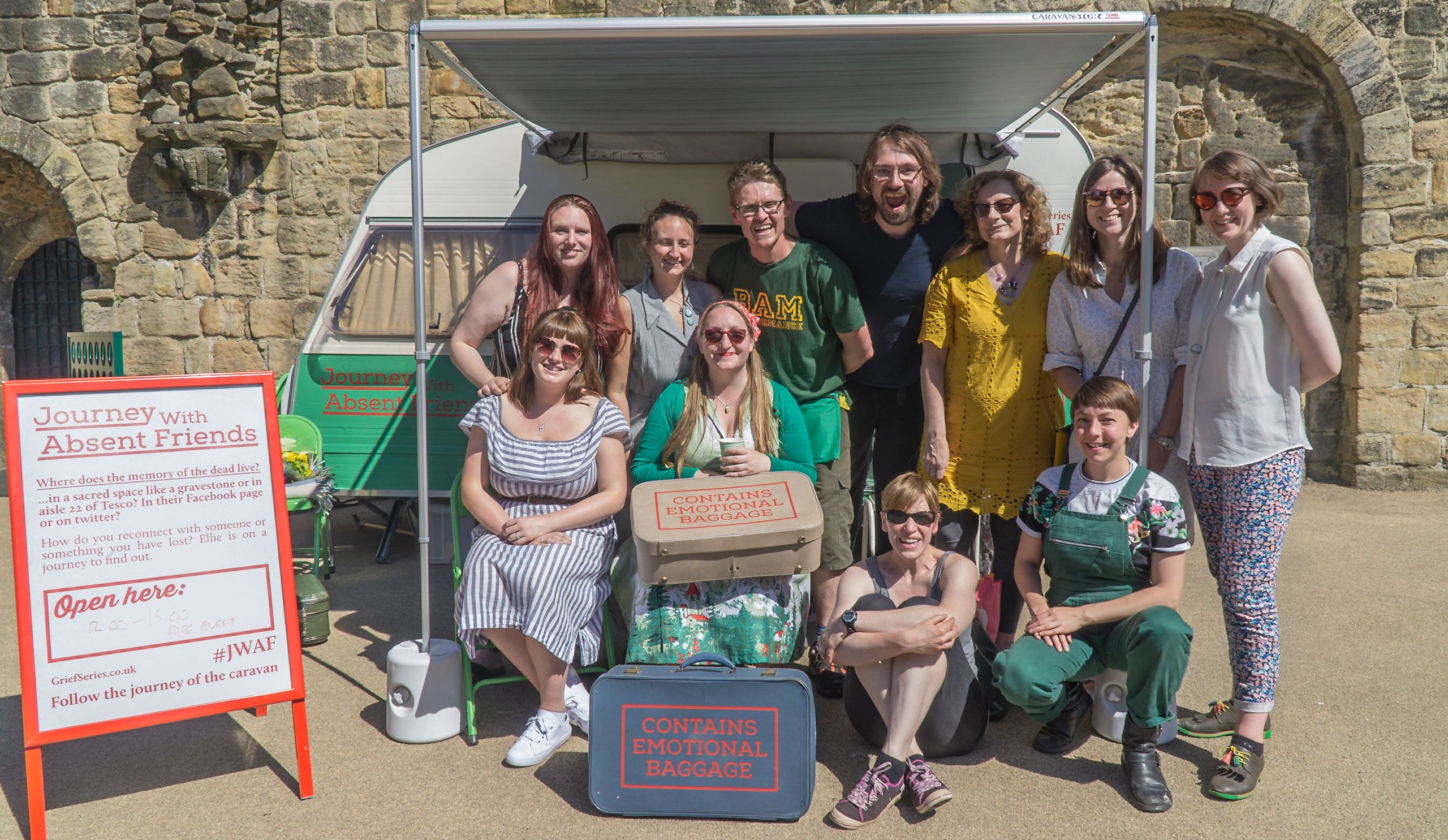 The'Journey with Absent Friends' team in front of a vintage caravan.