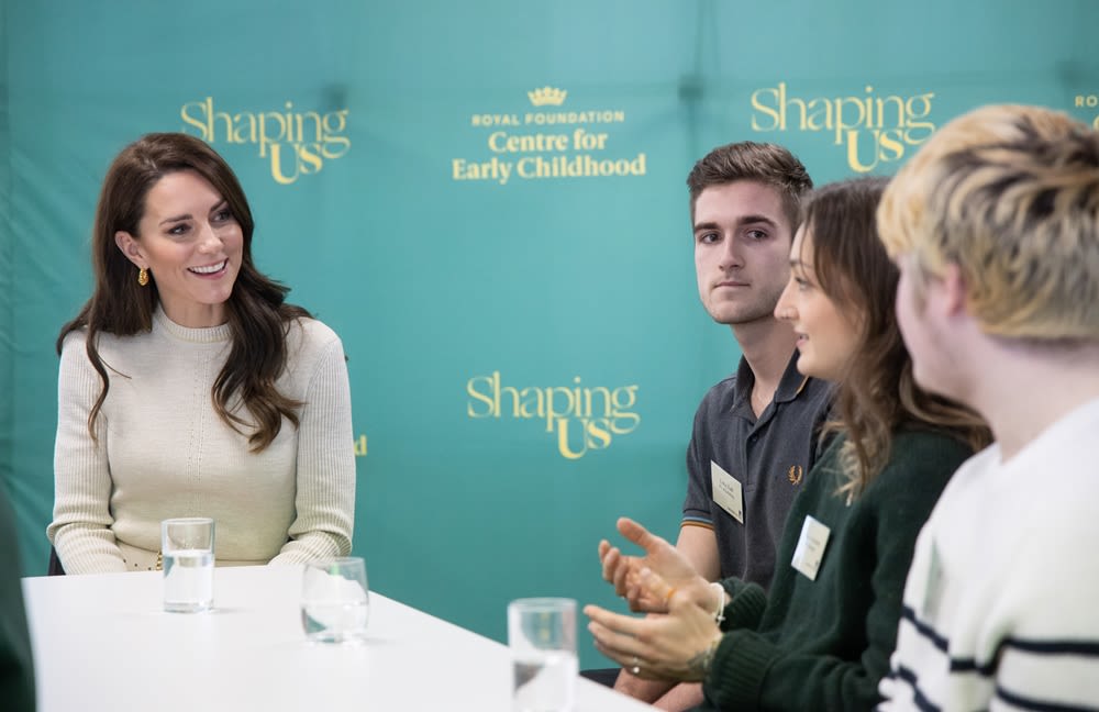 The Princess of Wales and three other people sit around a table in conversation. The banner behind says 'Shaping Us'.