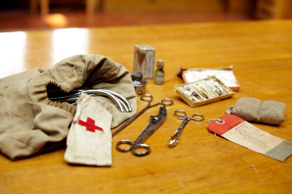 a cloth bag with a red cross, a cloth bag and various scissors