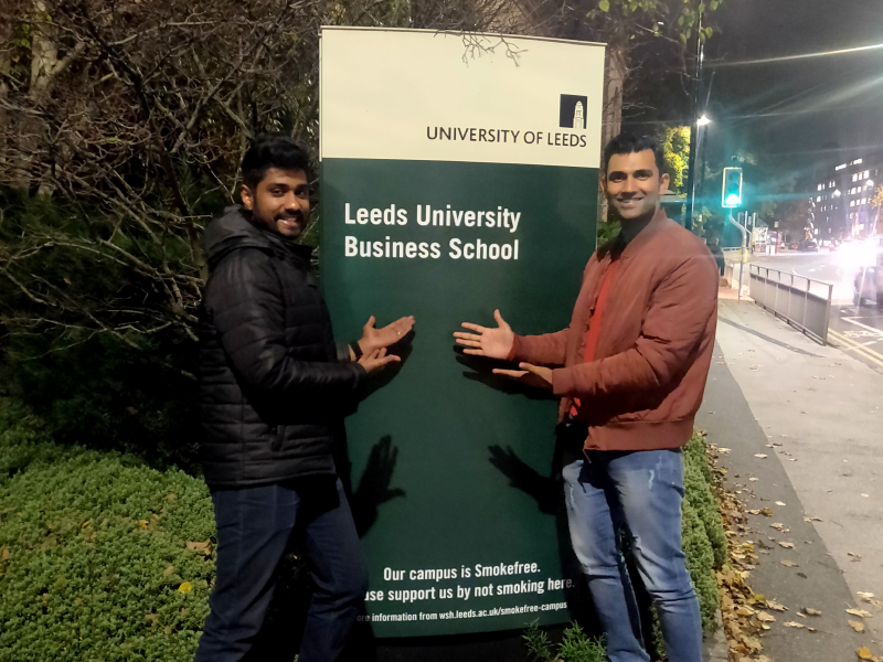 Gopakumar pose in front of the Business School sign