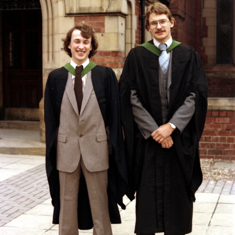 Two students stand together at graduation