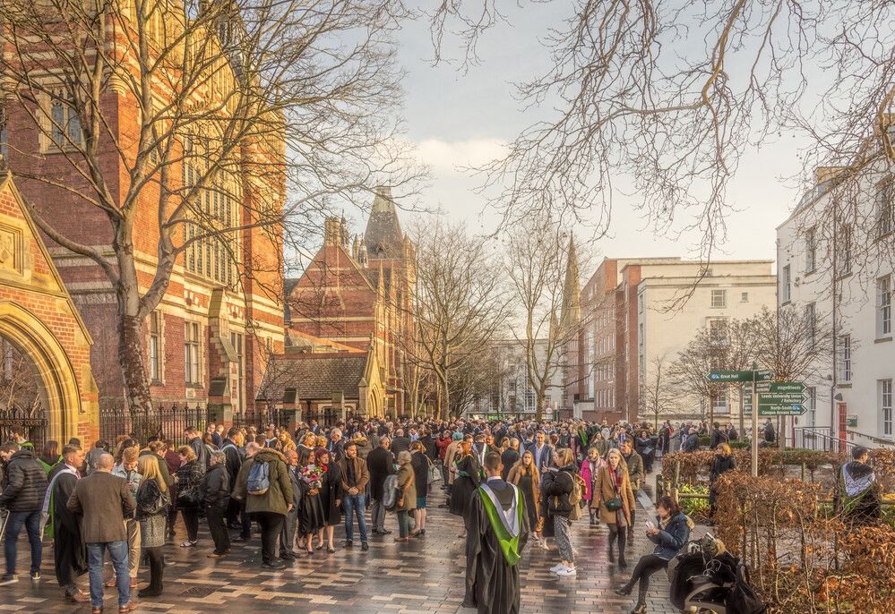 Graduates congregate outside a building in winter