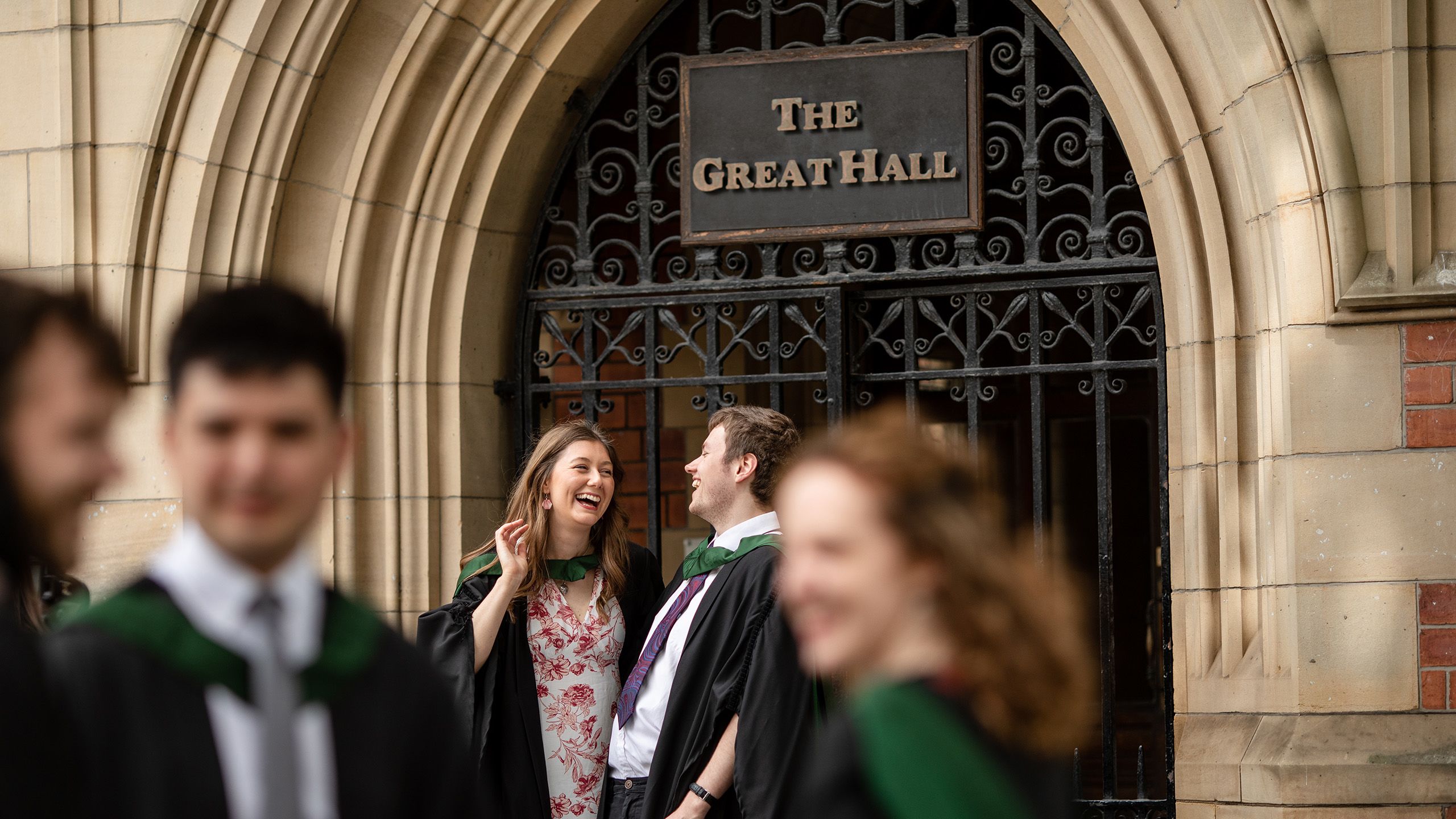 A close up of graduates in front of the entrance to the Great Hall