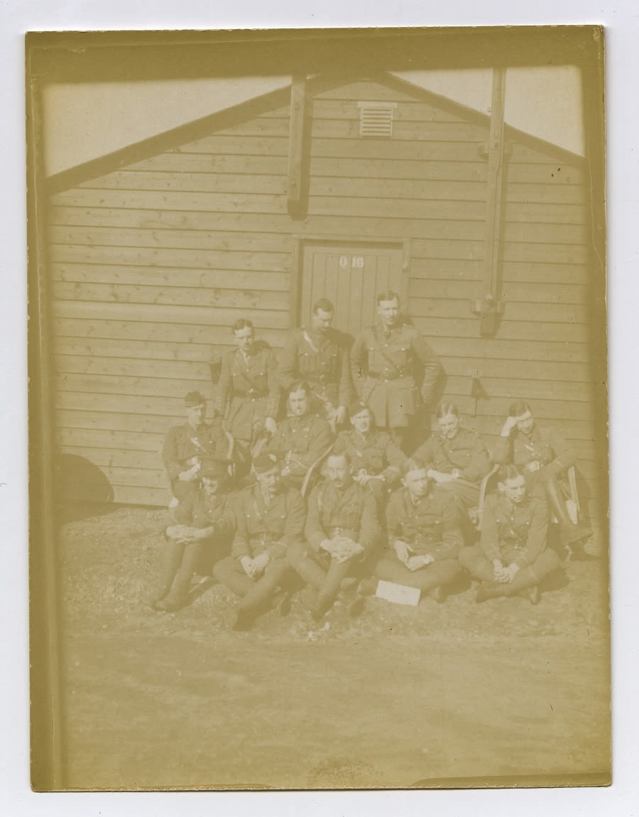 A faded sepia photograph of a group of soldiers. Described under heading: Read with soldiers