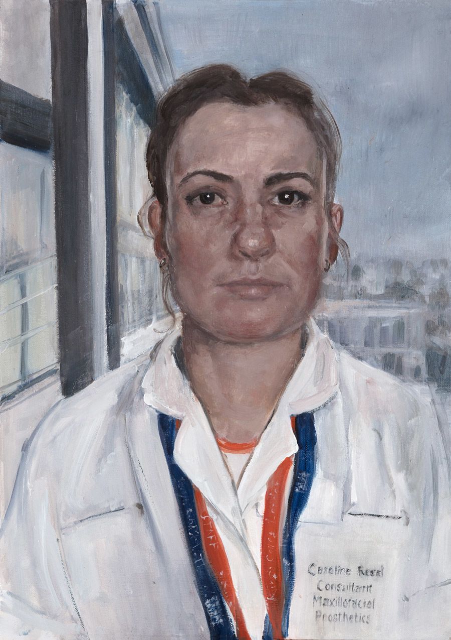 Portrait of Caroline Reed in a white medical uniform wearing lanyards
