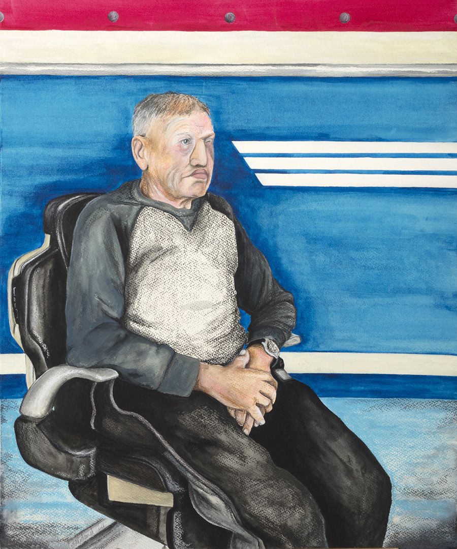 Portrait of David sat in an examination chair looking into the distance. 