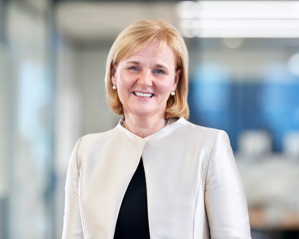 Professional portrait photo of Amanda Blanc. She is smiling for the camera and wearing a white jacket