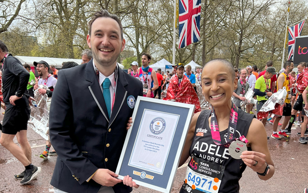 Adele Roberts is awarded a medal and certificate by an official at the end of the London Marathon