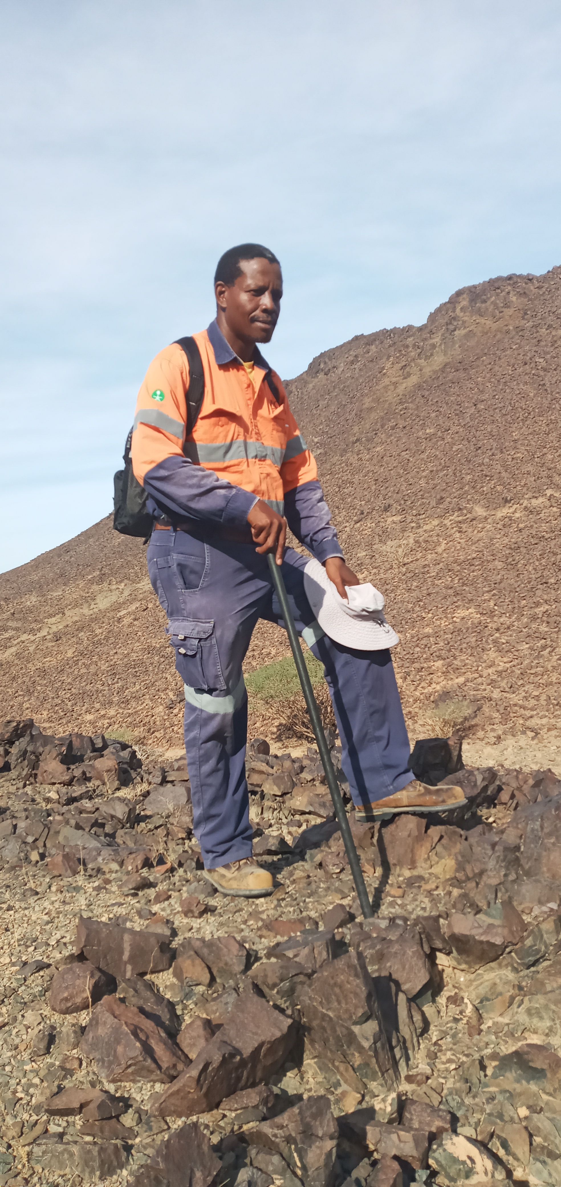 Man in work gear standing on rocks