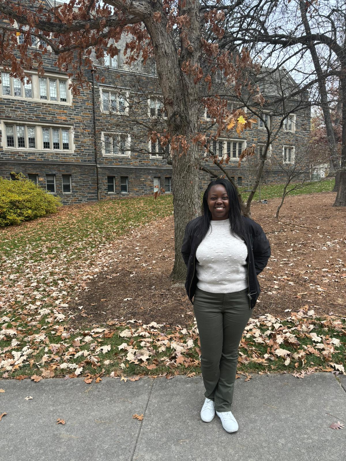 woman in front of tree with leaves on the ground