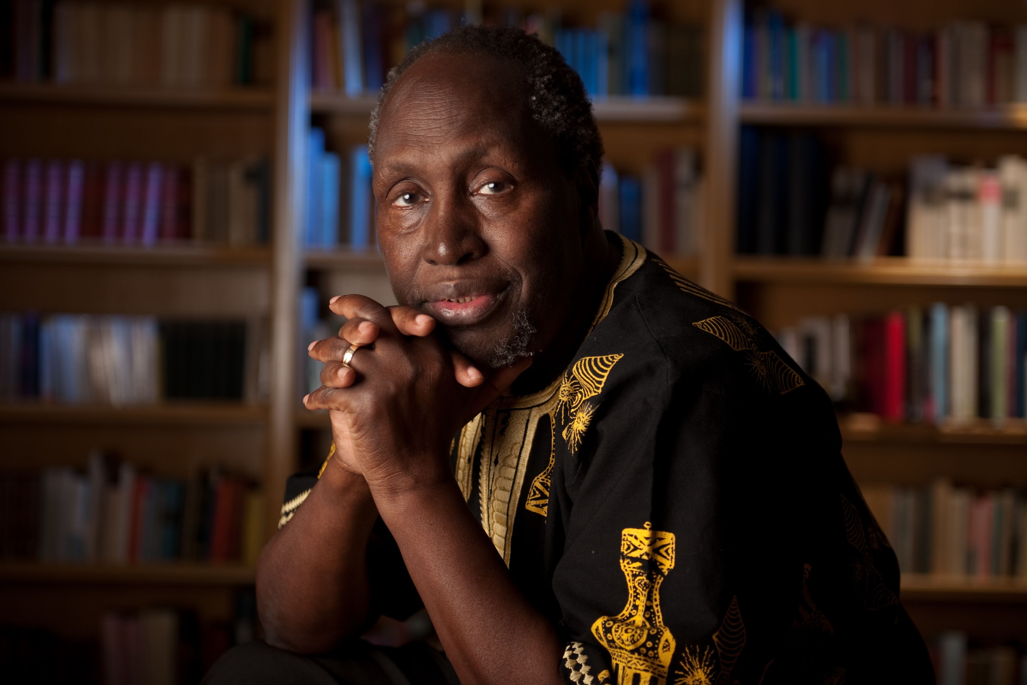 man with linked hands looking at camera