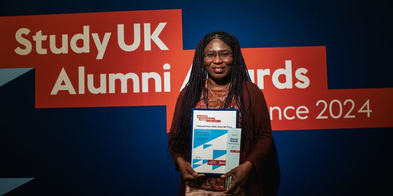 woman posing in front of Study UK alumni awards banner