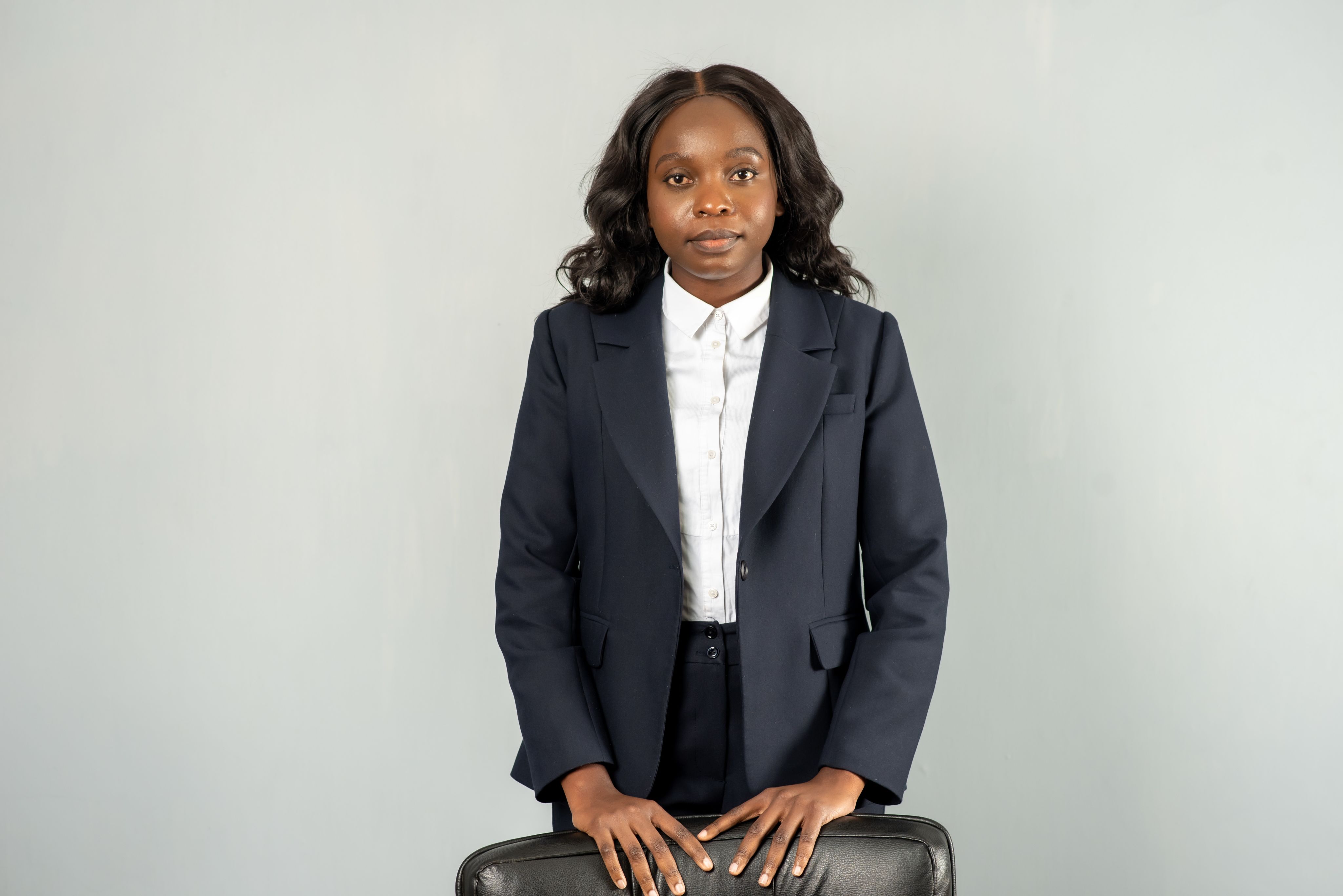 woman with hands on chair in jacket
