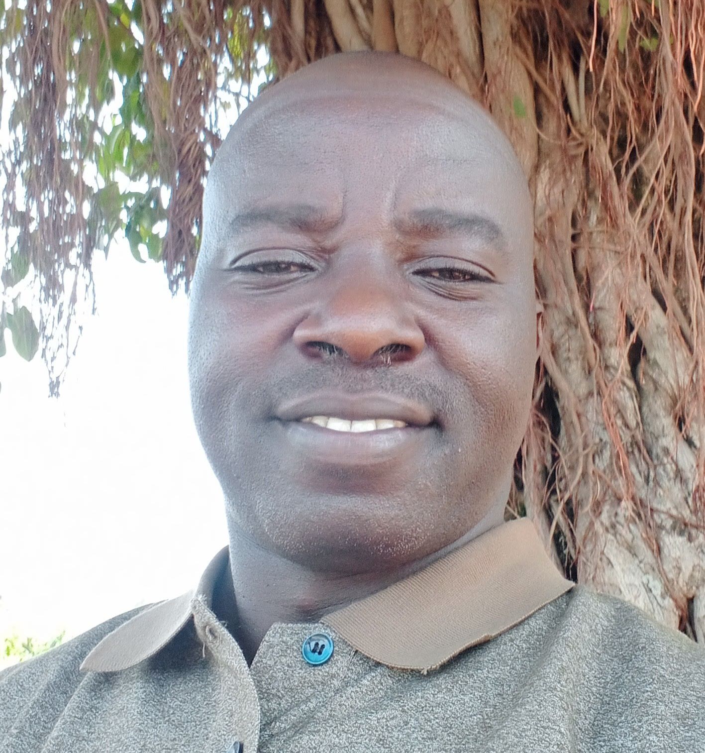 man in front of tree trunk