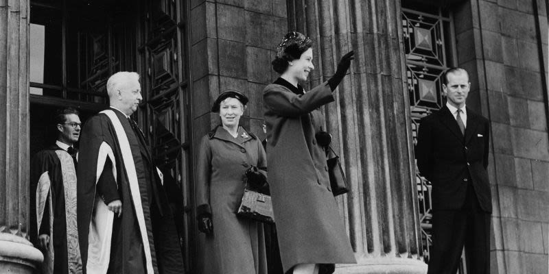 Queen stands and waves from the Parkinson steps