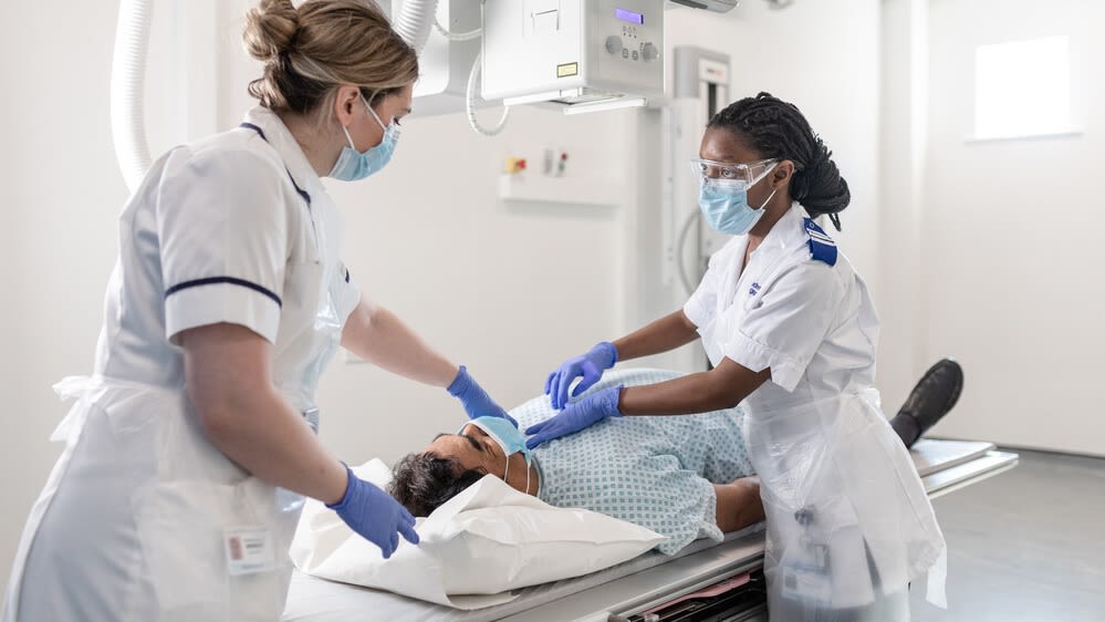 Two radiology students in the Clinical Skills Suite at Leeds General Infirmary, treating a patient