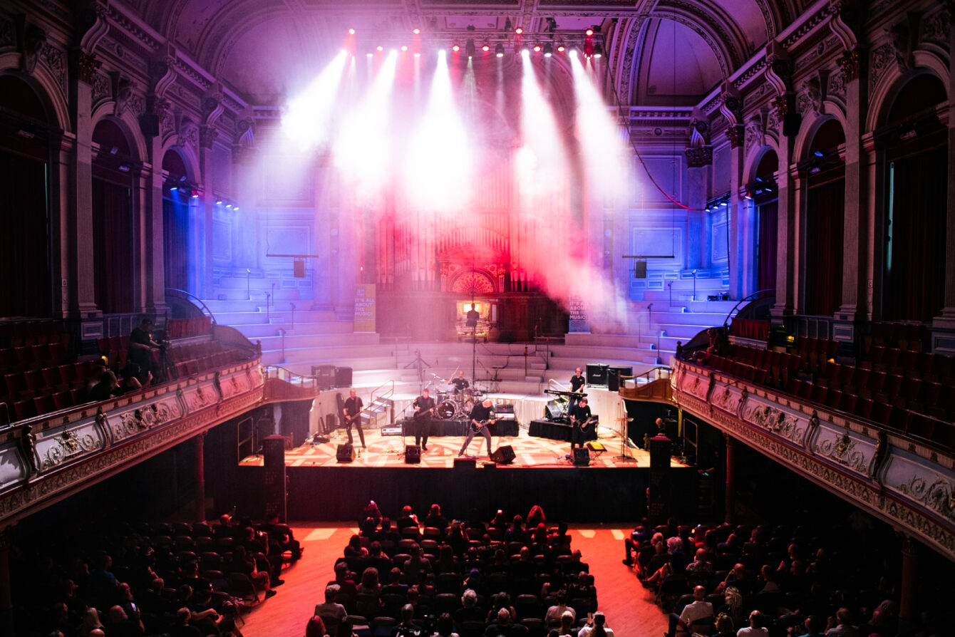 A band plays on stage to a live audience