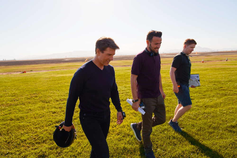 Three men walk across a field