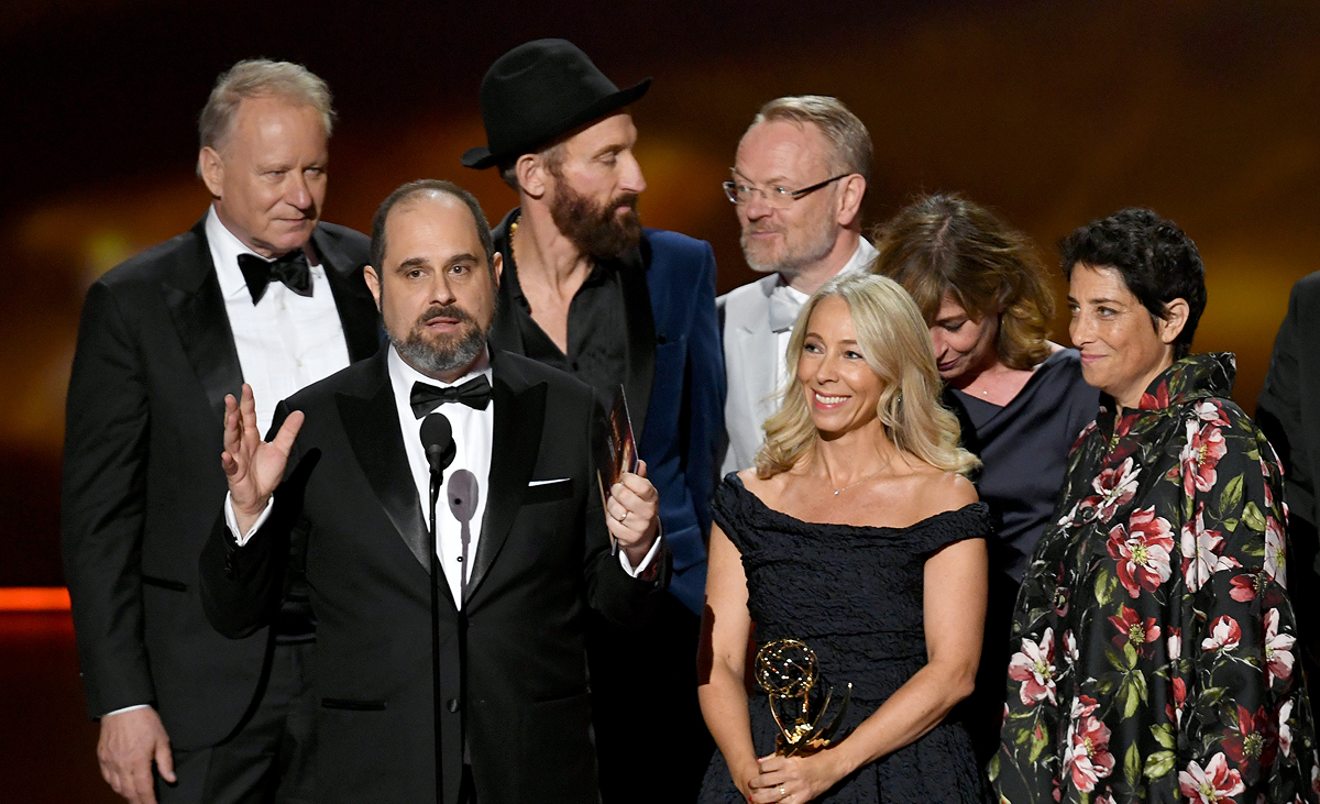 A group of individuals stand on stage at an award ceremony