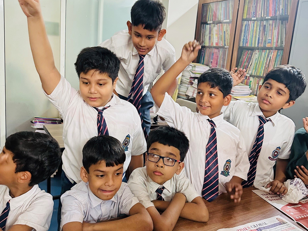 Children raise their hands in a classroom