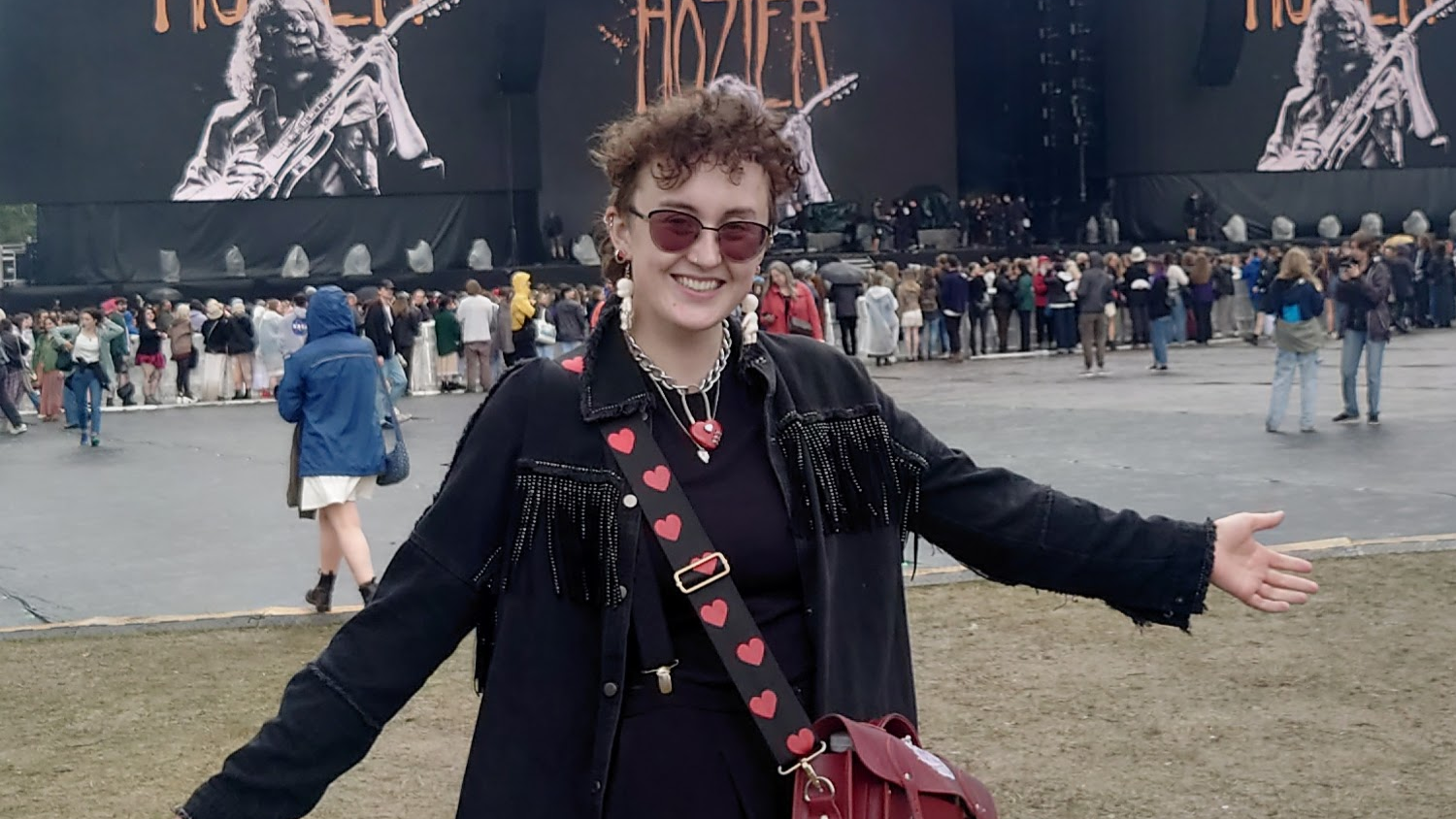 Maya stands in front of a stage at a festival