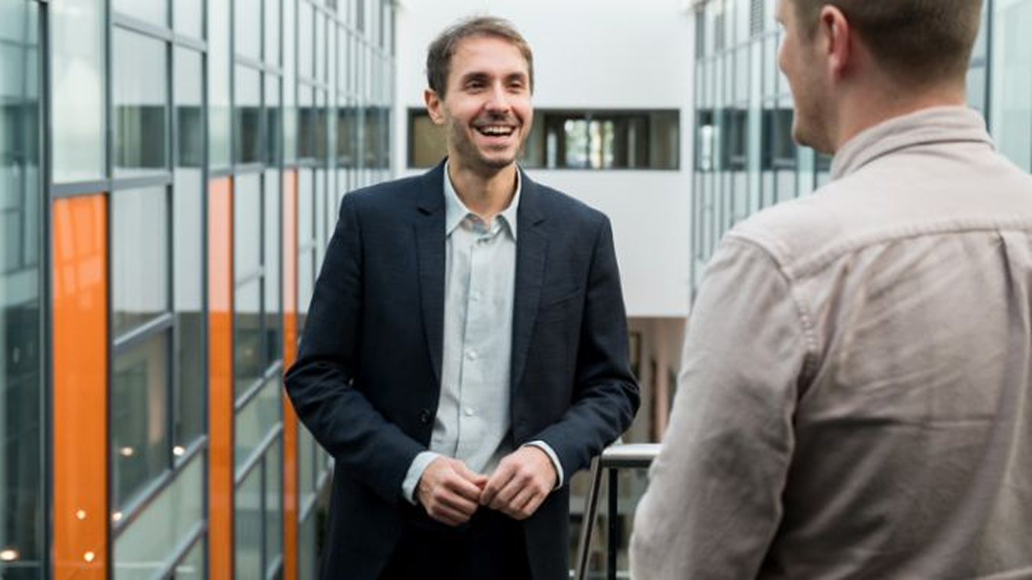 Ilias Trispiotis leans against a balcony, laughing