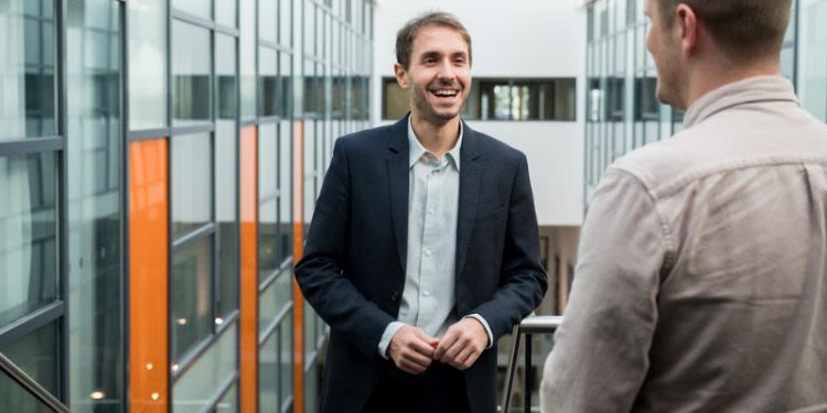 Ilias Trispiotis leans against a balcony, laughing