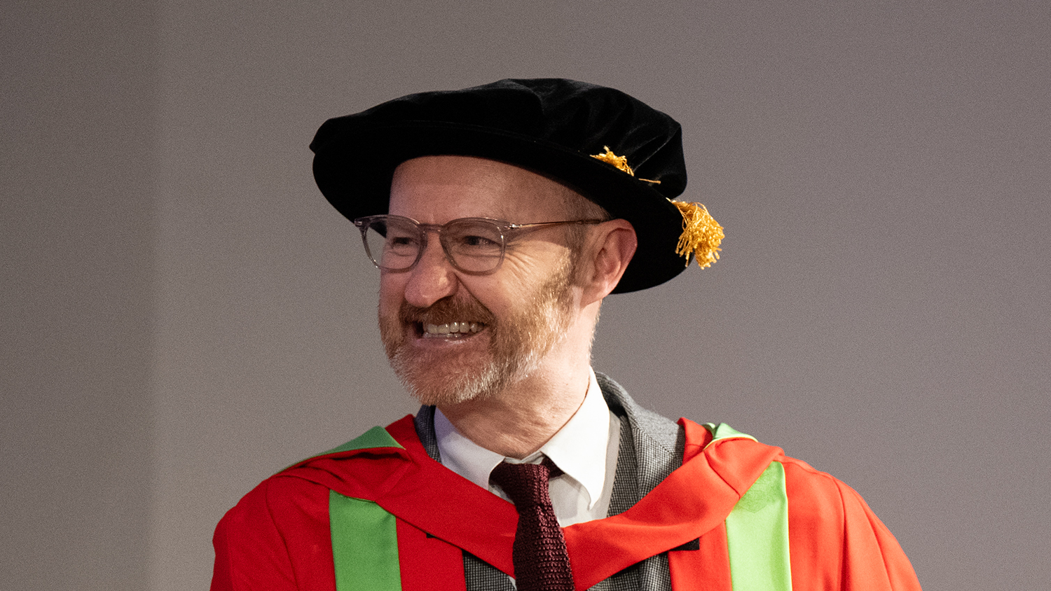 Mark Gatiss wearing academic gown and hat smiling