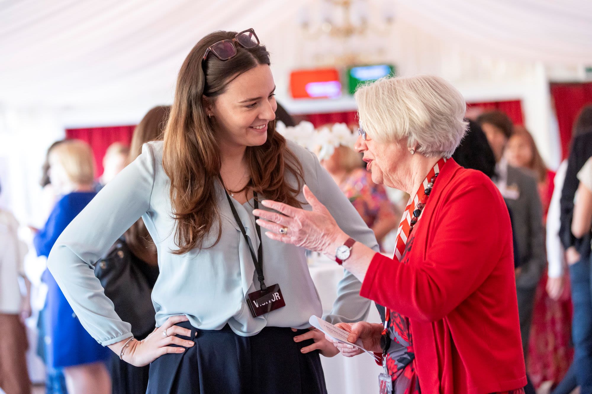 woman with hands on hips smiling at other woman