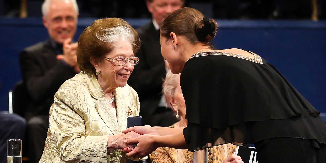 Dame Fanny Waterman smiles as she shakes hands.