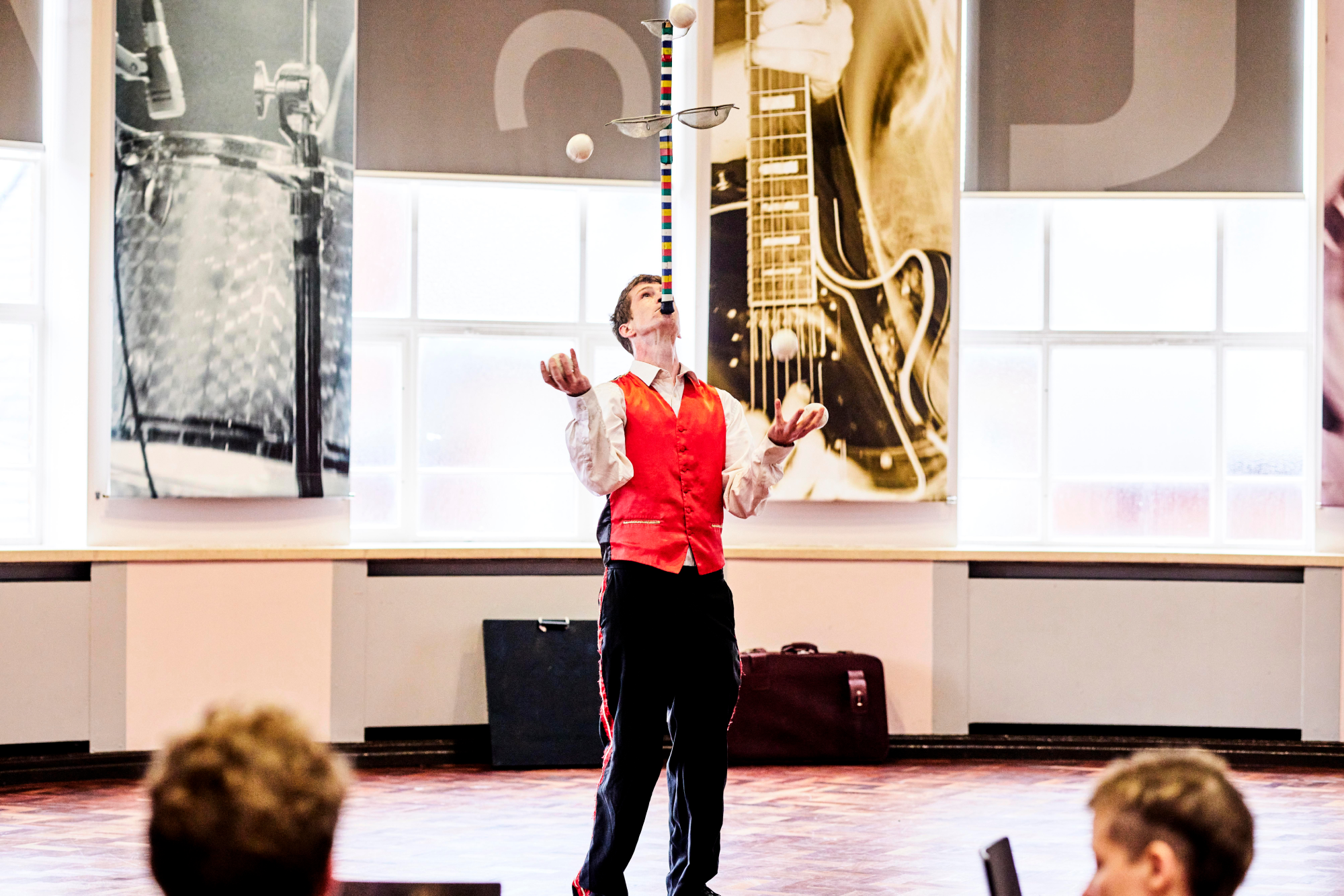 Man juggles with a pole balanced on his chin