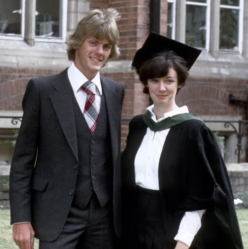 An old photo of a couple from the 1970s. The lady on the right is wearing a graduation gown and cap, the man on the right is wearing a three piece suit