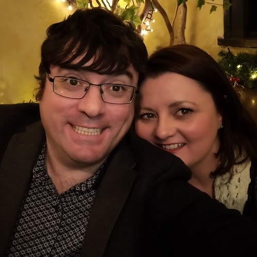 A selfie of a couple in a restaurant, both are smiling at the camera
