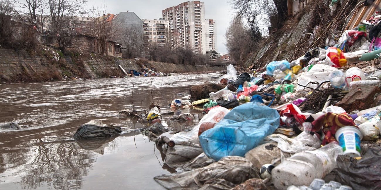 A river with plastic pollution collecting on an embankment.