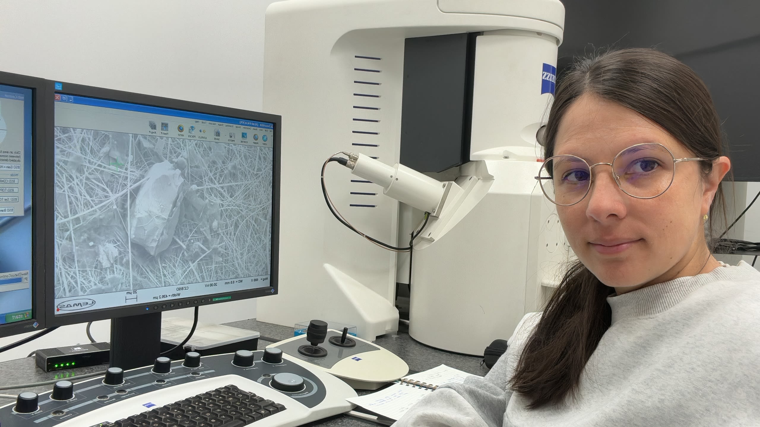 Alma Palacios-Marín, a third-year postgraduate researcher with a microscope