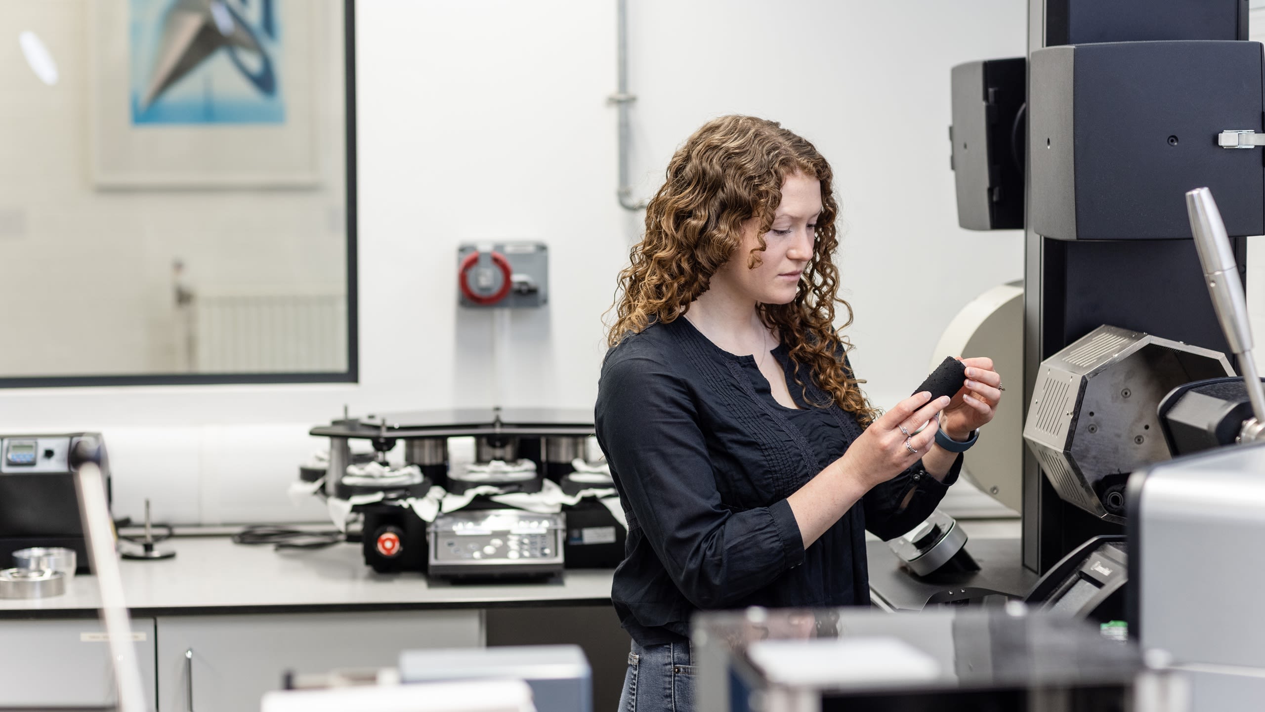 A person operating some textile equipment in a lab