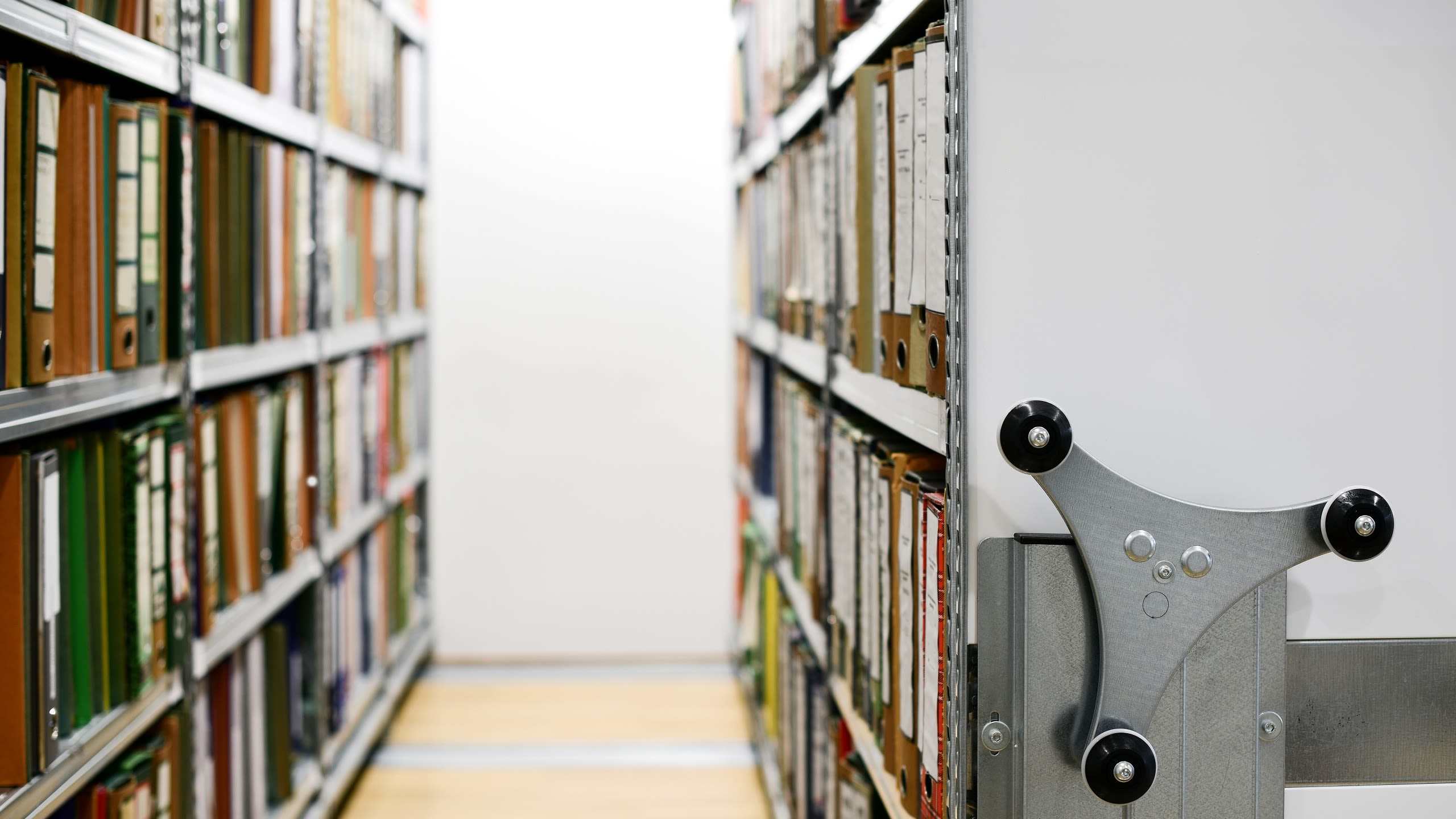 Inside an archive, showing two shelves filled with folders that you can walk down and a handle you can turn to view the shelves
