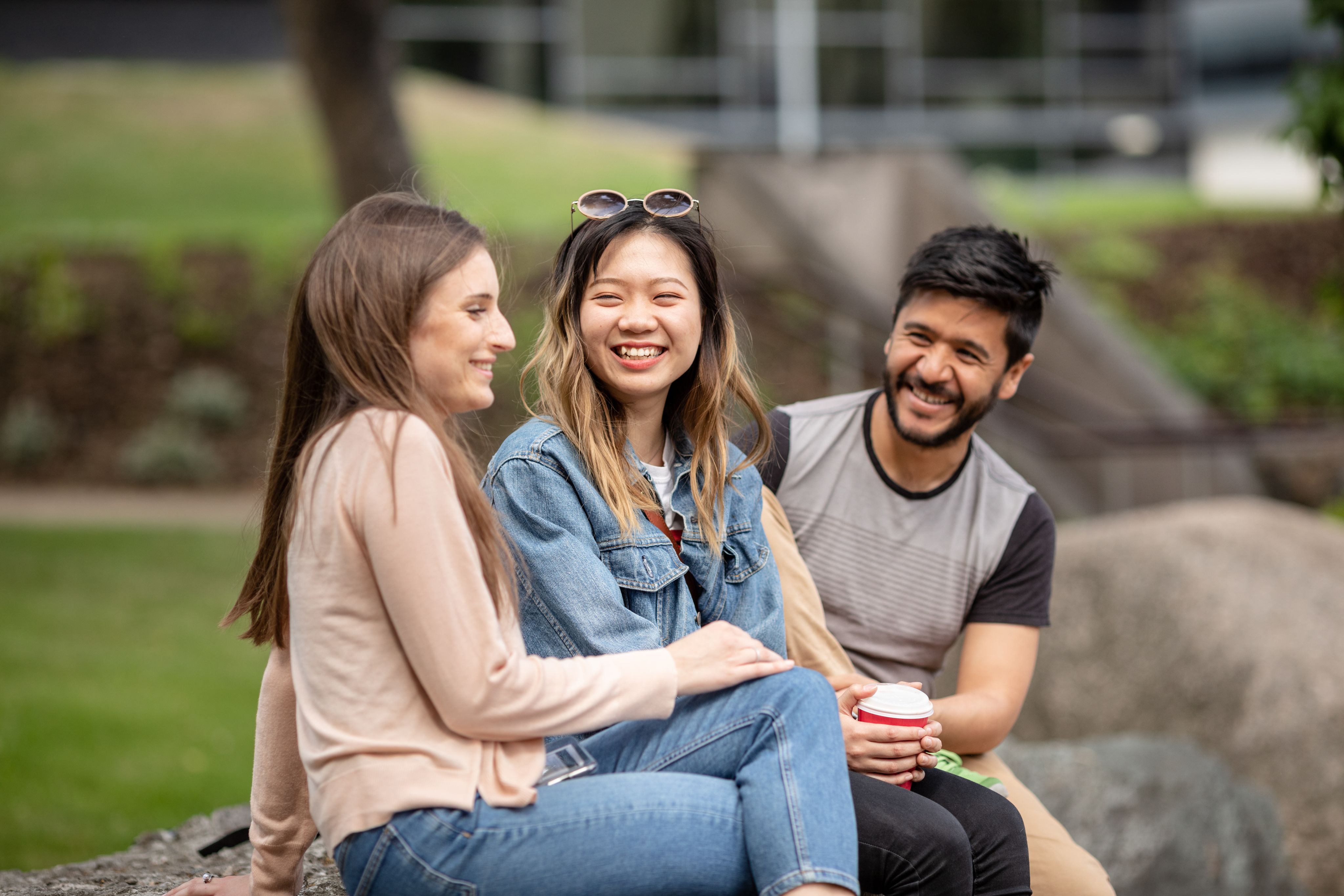 Students sat outside union on picnic table 