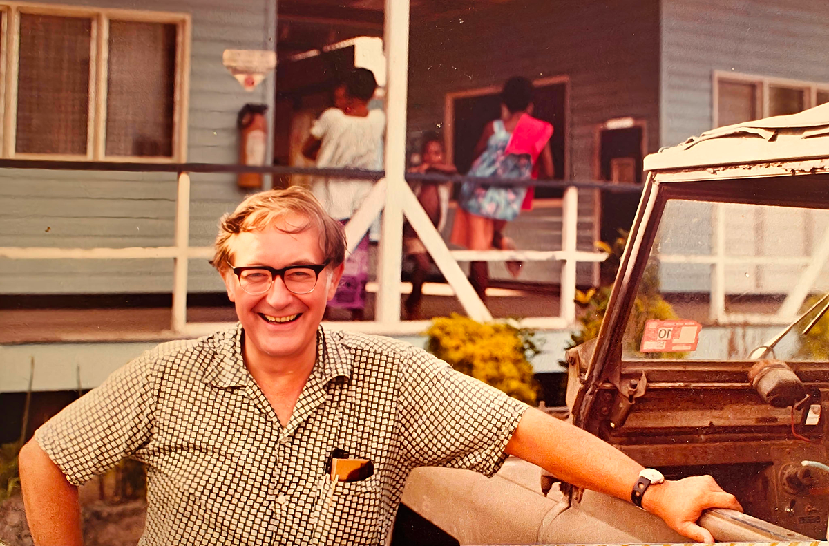 Geoffrey Howden laughs as he leans against a car door