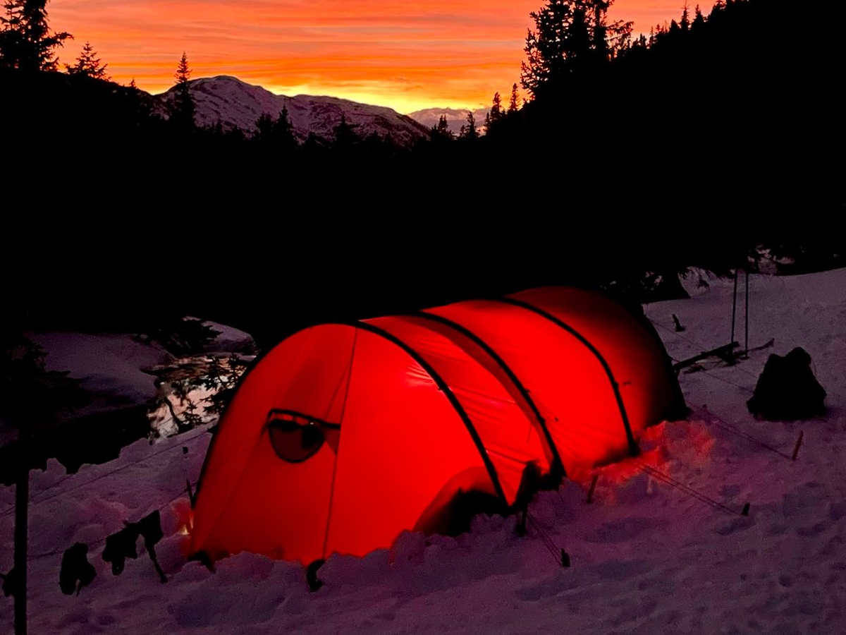 A tent glowing from a light inside in the night